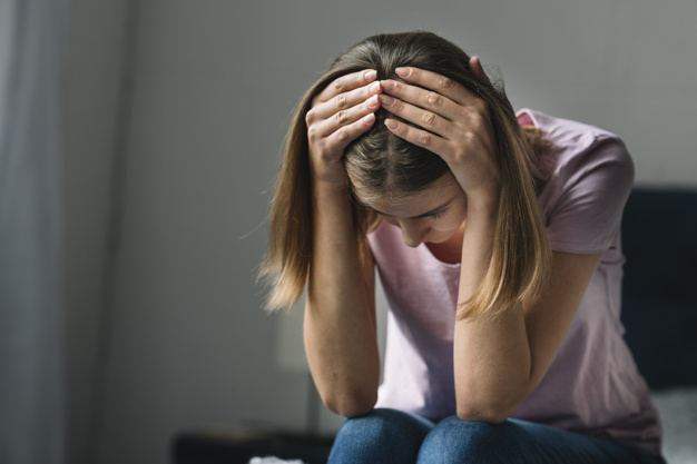 mujer con manos en la cabeza con la patologia depresión