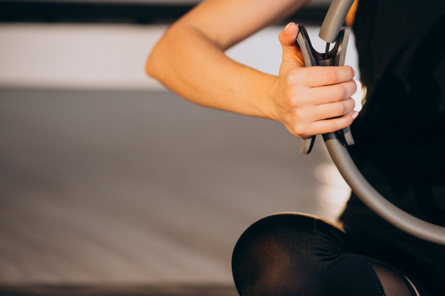 mujer sujetando un aro de pilates